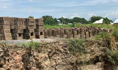 An image showing a pile of bricks next to a river.