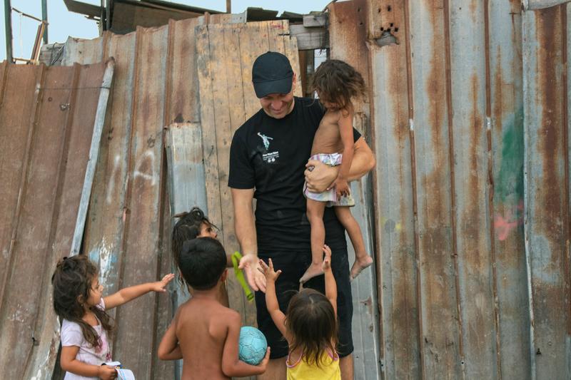 Gabriel playing with children photo by max damato Gabriel carrying one child and playing with four others by broken down fence