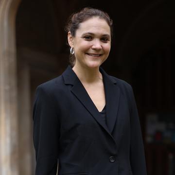 Professor Ann Kelly at Exeter College A woman in a black jacket outside an old stone building