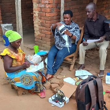 Three community members are being trained to trap, identify, and record mosquito data for a citizen science project.