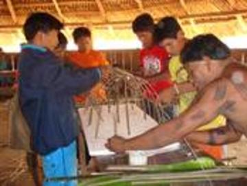 elders and youths building a model of a traditional panara house brazil