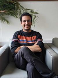 Tanuj luthra A man sitting in a grey chair smiling