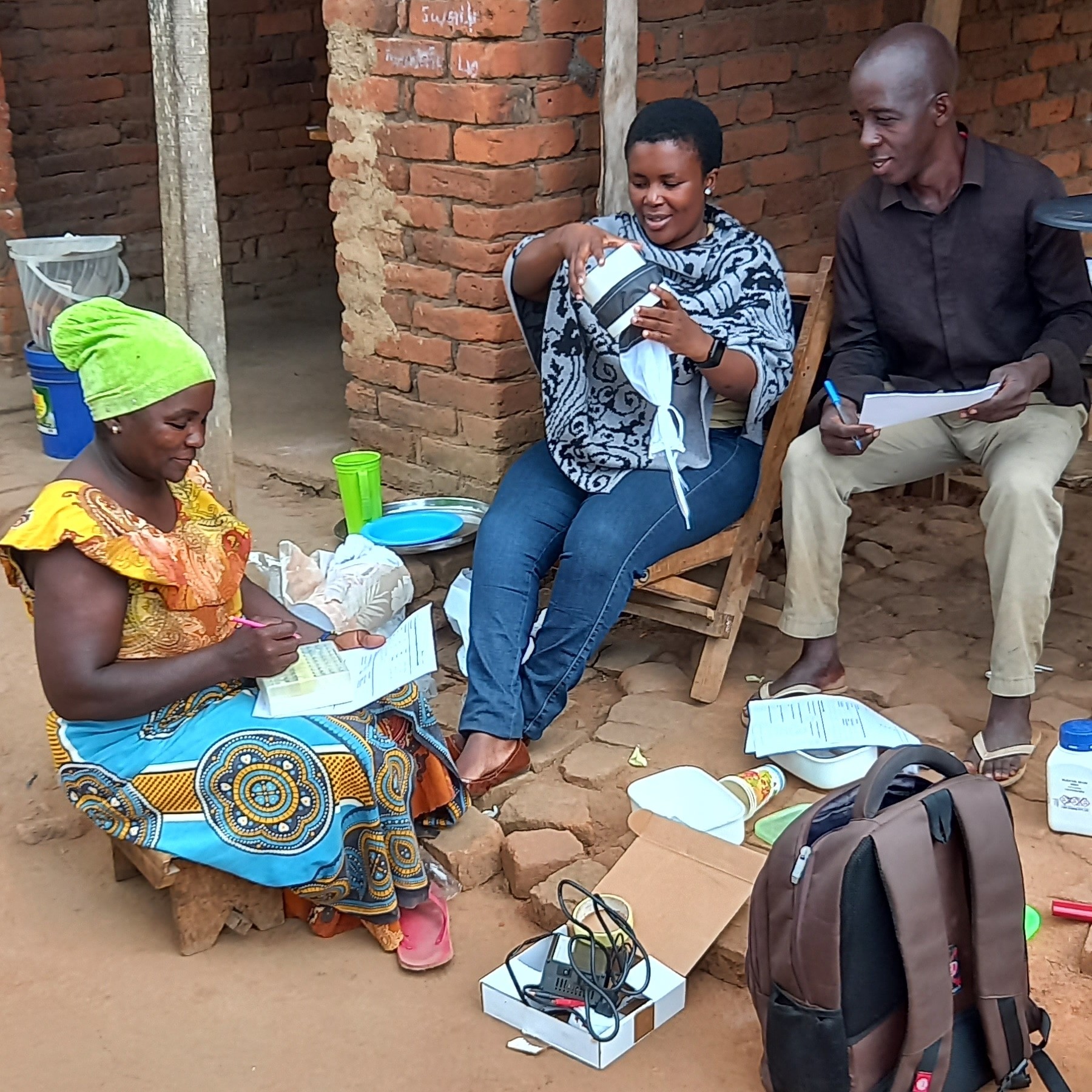 Three community members are being trained to trap, identify, and record mosquito data for a citizen science project.