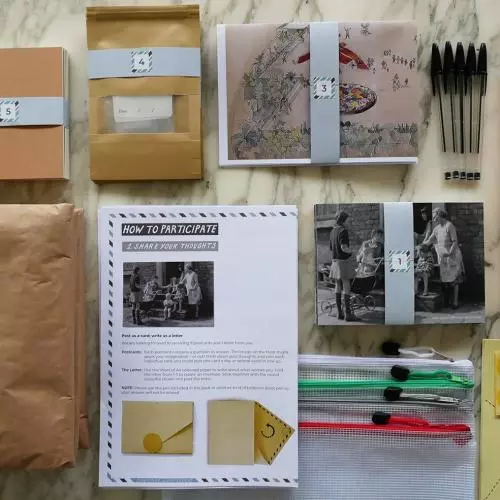 Camera,s bags, postcards and instructions laid out on a table