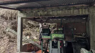 A roofed beneficiadero, where harvested coffee cherries are brought for processing, at the Bellavista farm, in a vereda (rural district) of the municipality of Arboledas, Norte de Santander. In the foreground are two cement fosas (basins); in the backgrou