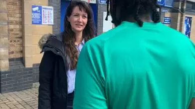 Woman talks to man outside prison