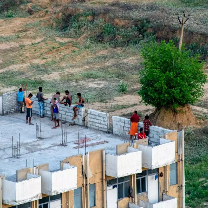 people working on top of a building under contstruction