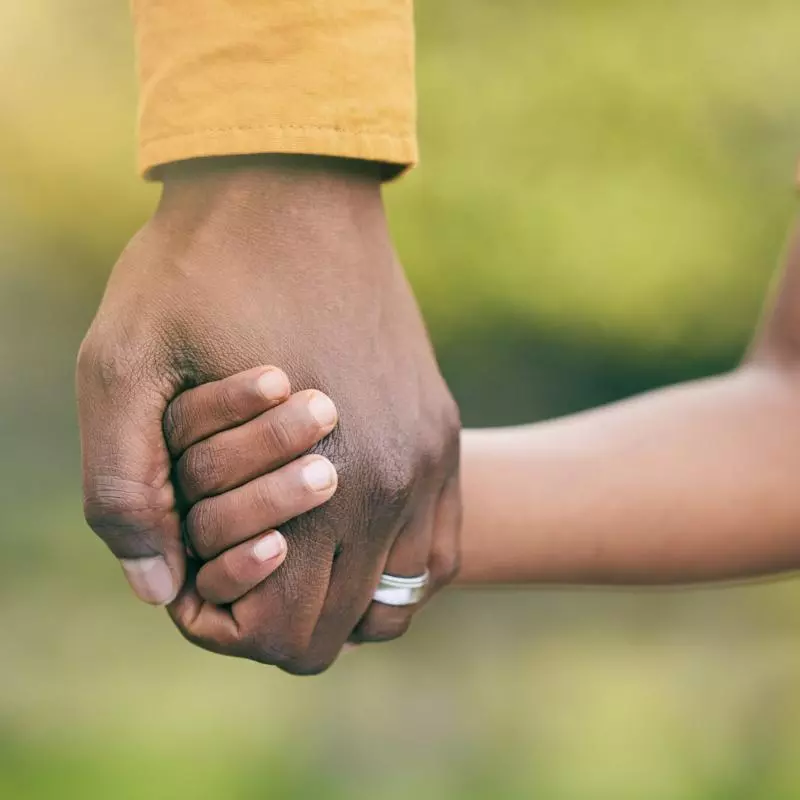 A man's hand holding a childs