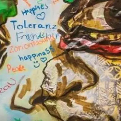 Drawing of face wuth pattern colours and words including friendship, happinas and toleranz 