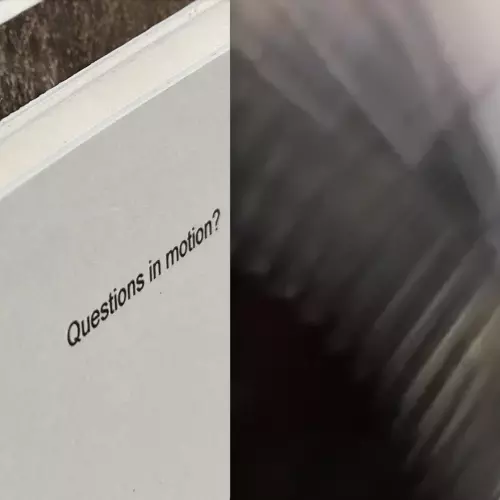 'questions in motion' typed on a card with blur