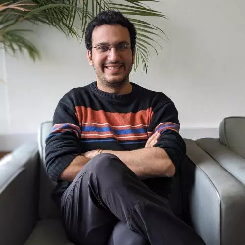 A man sitting in a grey chair smiling