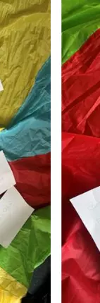 colourful parachute with crayons and paper laid out on the floor