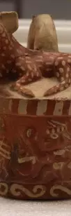 small clay pot with dear like animal on top